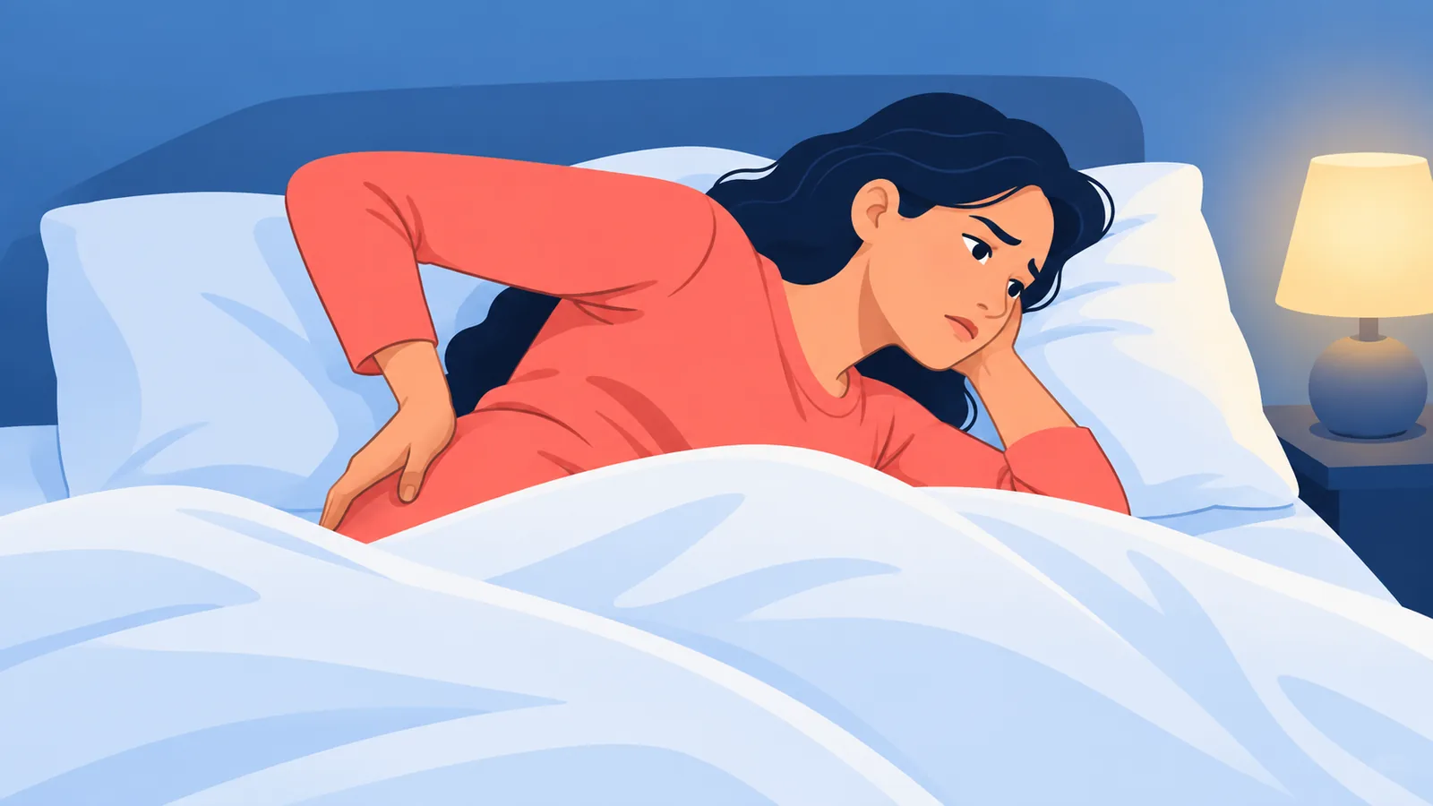 Persona despierta en la cama de noche con la mano sobre la zona lumbar